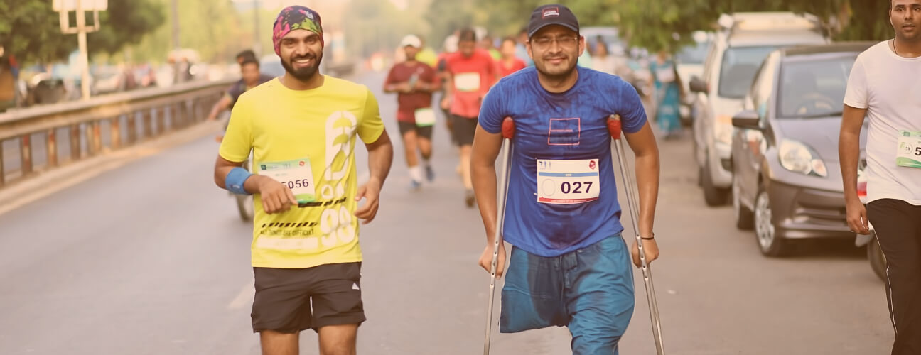  A person with disability and an ally run in a marathon together. They both look into the camera and smile as they run to spread the idea of inclusion.
